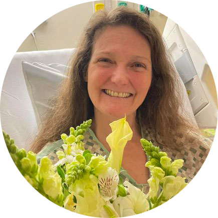 Cathy smiling with yellow floral bouquet